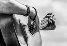 Acoustic guitars playing. Music concept. Black and white. Male musician playing guitar^ music instrument. Man's hands playing acoustic guitar^ close up.