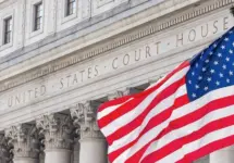 American flag waving in the wind in front of United States Court House in New York