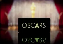 A smartphone displaying the Oscars logo against a blurred awards ceremony background. January 13^ 2025