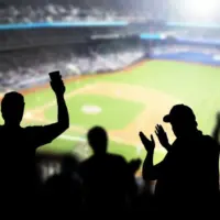 Baseball fans and crowd cheering in stadium and watching the game in ballpark. Happy people enjoying a match and sport event in arena. Friends watching ballgame live.