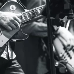 Rock and roll music background^ guitar players on a stage^ monochrome photo with selective focus