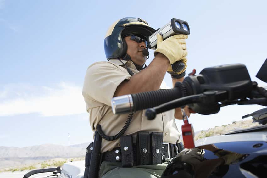 low-angle-view-of-a-police-officer-looking-through-radar-gun