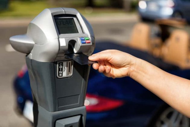 hand-putting-credit-card-into-parking-meter-for-time