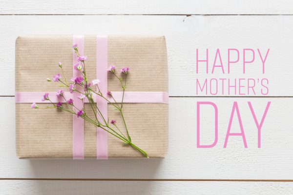 white-wooden-table-with-pink-flowers-and-a-present-mothers-day-concept