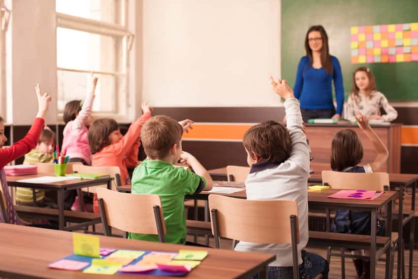 children-in-elementary-school-are-raised-hand-in-clasroom