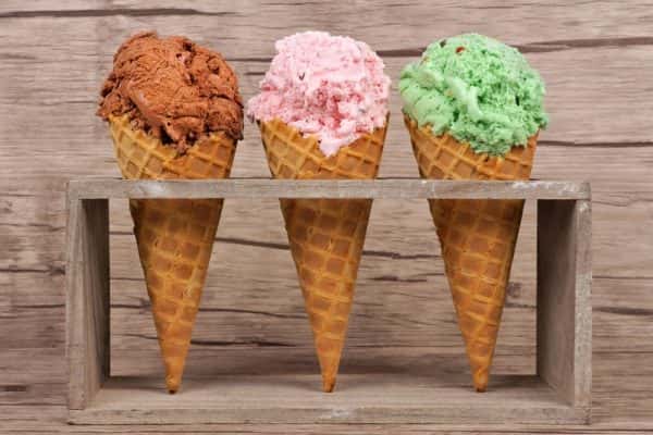 chocolate-cherry-and-pistachio-ice-cream-in-waffle-cones-in-rustic-holder-over-a-wood-background
