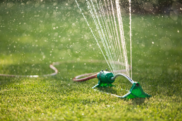 lawnsprinklerspayingwaterovergreengrass-irrigationsystem