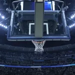 Brightly lit Basketball backboard in a large sports arena.