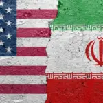 United States of America vs Iran - Cracked concrete wall painted with a USA flag on the left and a Iranian flag on the right