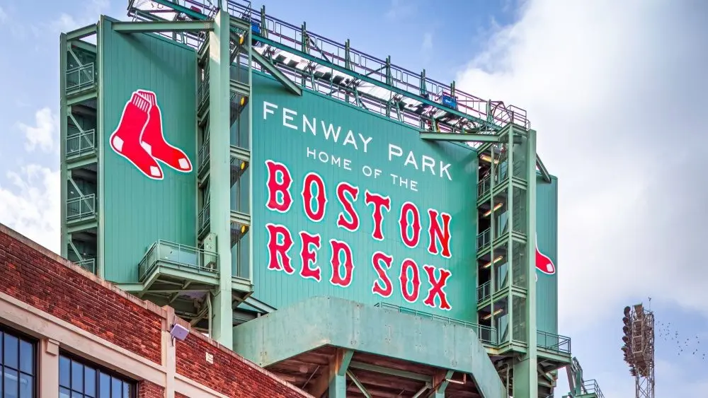 Vew of the historic architecture of the Famous Fenway Park Stadium in Boston^ MA^ USA showcasing its huge sign^ old brick walls^ and entrances on Lansdowne street. Boston^ MA^ USA - March 1^ 2023