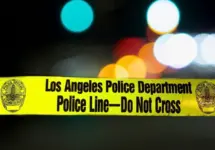 Police barricade tape with the writing 'LOS ANGELES POLICE DEPARTMENT POLICE LINE - DO NOT CROSS' illuminated night exterior with deliberately blurred background Los Angeles - January 2^ 2021