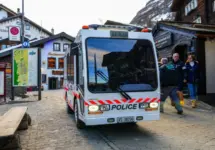 Zermatt^ Switzerland - Feb 19^ 2024 : Police vehicle in the city center of the ski resort of Zermatt in the Canton of Valais^ Switzerland - Narrow electric car Jumbolino in a car-free town of the Swis