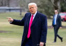 President Donald Trump points while on the South Lawn as he walks into the White House. WASHINGTON – February 22^ 2025