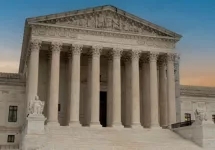 Greek classical architecture of the United States Supreme Court building with sunrise in background.