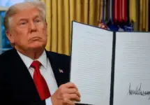 President Donald Trump signs executive orders in the Oval Office of the White House on January 20^ 2025 in Washington^ DC.