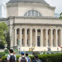 Students at the Columbia University campus on the Upper West Side of Manhattan. Steps of the Low Memorial Library in the background. New York^ NY^ USA - July 8^ 2022:
