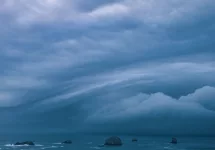 Storm clouds from bomb cyclone over sea stacks in the ocean at the Oregon Coast.