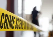 crime scene tape in building with blurred forensic team background