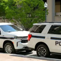 Police patrol cars used by the FBI parked on a street outside the J Edgar Hoover headquarters building in downtown Washington DC. Washington DC^ USA - 30 April 2024
