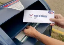 A man puts an absentee mail-in ballot in the mailbox. Circa August^ 2020