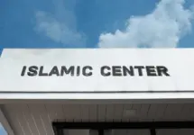 Islamic Center sign on a community building under blue sky^ symbolizing worship^ cultural education^ Muslim community services^ faith^ and spiritual guidance