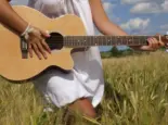 Country girl with guitar at wheat field