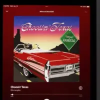 An Apple iPad displays the Spotify music streaming application^ which is playing the song "Choosin' Texas" by the artist Ella Langley