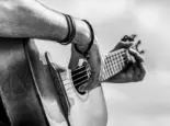 Acoustic guitars playing. Music concept. Black and white. Male musician playing guitar^ music instrument. Man's hands playing acoustic guitar^ close up.