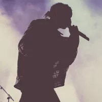 silhouette of rapper (male) performing on stage with mic