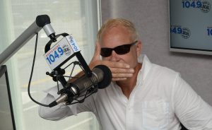 Dana Crypto in north shore 1049 studio with sunglasses on and hand over mouth