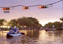 Working traffic lights over flooded Houston streets and boats with people at sunset. Texas^ USA