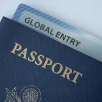 Global Entry card (Trusted traveller) covered of Passport of United states on white background.