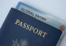 Global Entry card (Trusted traveller) covered of Passport of United states on white background.