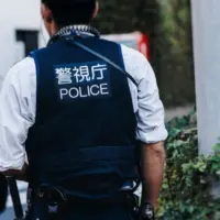 Japanese police squad formation in protective uniform with "Police" logo^ policemen patrol maintain public during political demonstration protest rally in the streets of Tokyo city center^ Japan