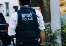 Japanese police squad formation in protective uniform with "Police" logo^ policemen patrol maintain public during political demonstration protest rally in the streets of Tokyo city center^ Japan