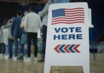 Vote here sign on the floor. Queue of multi ethnic American citizens come to vote in polling station. National Election Day in United States. Political races of US presidential candidates. Civic duty.