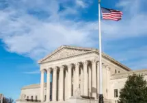 Facade of the United States Suprement Court with American flag in Washington^ DC
