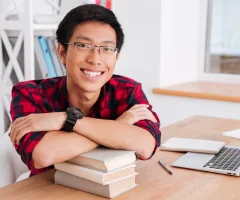 cheerful-student-guy-has-leaned-the-elbows-on-books