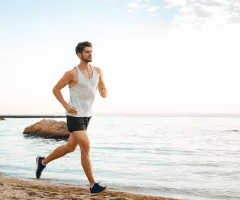 handsome-man-athlete-running-at-the-beach