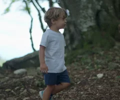 child-walking-outside-in-nature-little-boy-walks-outdoors-in-green-path-2-sbi-351579072