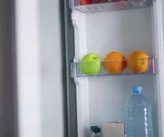 young-woman-opens-fridge-puts-apples-and-oranges-inside-then-closes-it-caucasian-femal-sbi-349929286