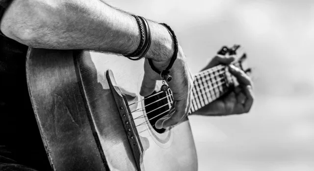 Acoustic guitars playing. Music concept. Black and white. Male musician playing guitar^ music instrument. Man's hands playing acoustic guitar^ close up.