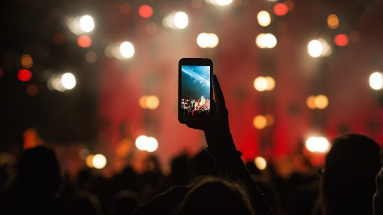 fan-taking-photo-with-cell-phone-at-a-concert