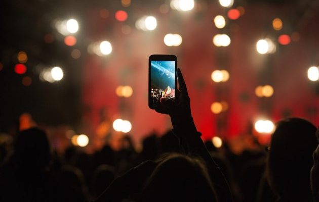 fan-taking-photo-with-cell-phone-at-a-concert