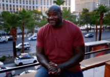 shaq-sitting-on-a-balcony-above-a-busy-street-png-3