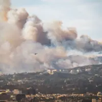 Wildfire in Pacific Palisades^ Los Angeles^ January 8^ 2025^ towards Getty Center and Brentwood. Images showcase dense smoke clouds^ burning hillsides^ and urban areas at risk. 2pm - 3pm.