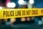 Yellow Tape Showing Text "Police Line Do Not Cross" Restricting a Crime Scene Area At Night. Close Up Aesthetic Shot with Bokeh Effect and Flickering Lights. Criminal on the Loose Strikes Again