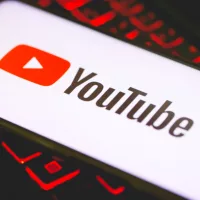 YouTube logo on the screen of a smartphone that is over a keyboard