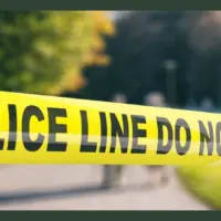 Police line outdoors. Warning yellow tape^ text police line do not cross^ blur park nature background. 3d illustration