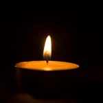 Lit memorial candles in the dark^ burning candles